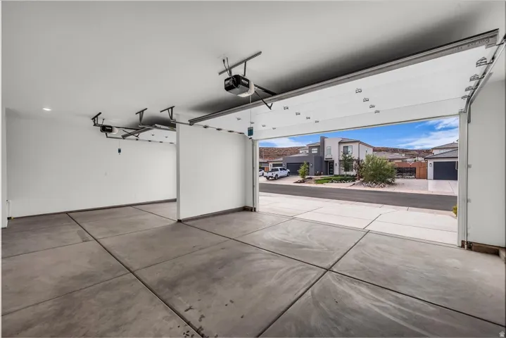 Attached two-car garage with concrete flooring and exposed garage door mechanisms