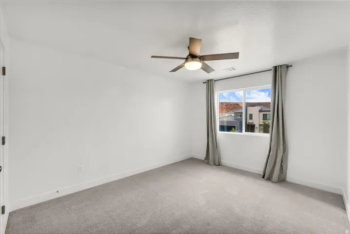 Recessed lighting, wood-finish ceiling fan, window with curtain rod, and carpeted flooring