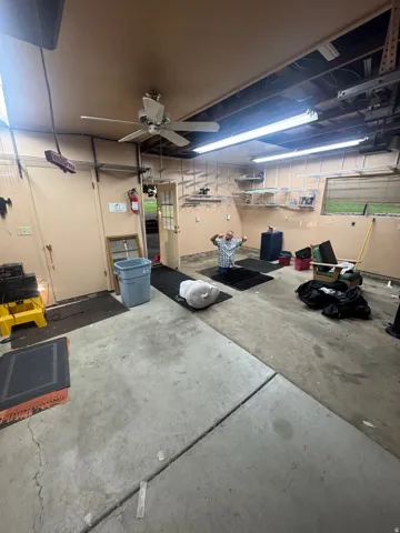 Concrete flooring, ceiling fan, fluorescent lighting, interior door, and window