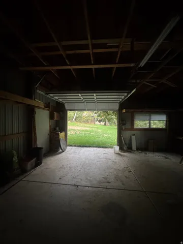 Concrete flooring, exposed ceiling joists, and a roll-up garage door