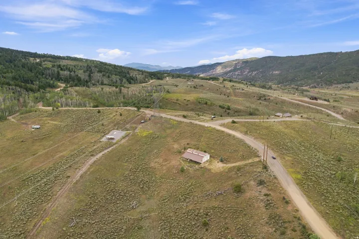 Expansive mountain landscape with rolling terrain and scattered structures