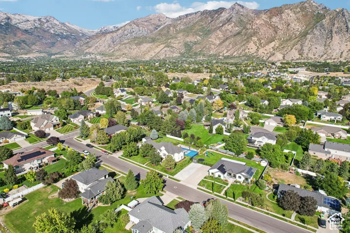 Residential area with mature trees and mountain backdrop