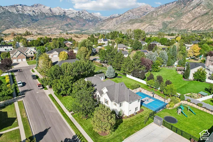 Expansive lot featuring a sports court, mature landscaping, and mountain backdrop
