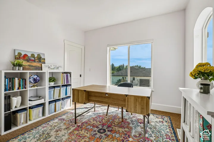Bright room featuring two windows, a paneled door, and built-in shelving