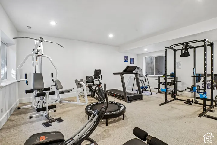 Carpeted recreation space with recessed lighting and multiple windows