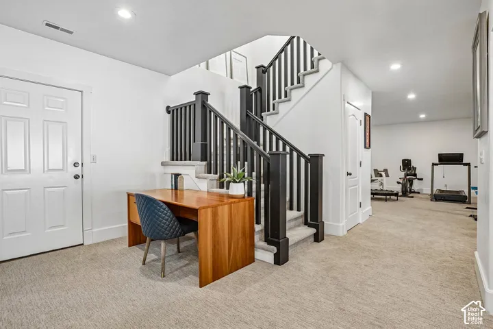 Carpeted flooring, recessed lighting, and a paneled interior door