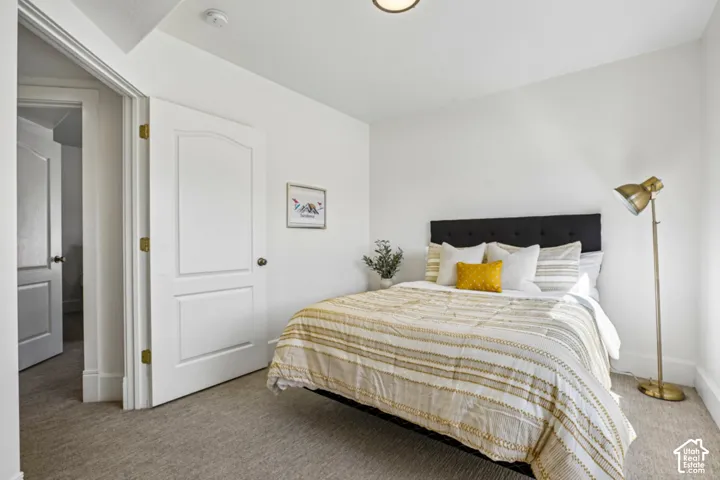 Recessed ceiling lighting, light-toned wall finishes, paneled interior door with curved top detail, carpeted flooring