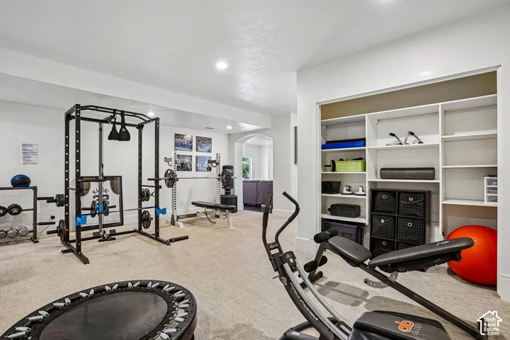 Carpeted recreation room with recessed lighting and built-in shelving