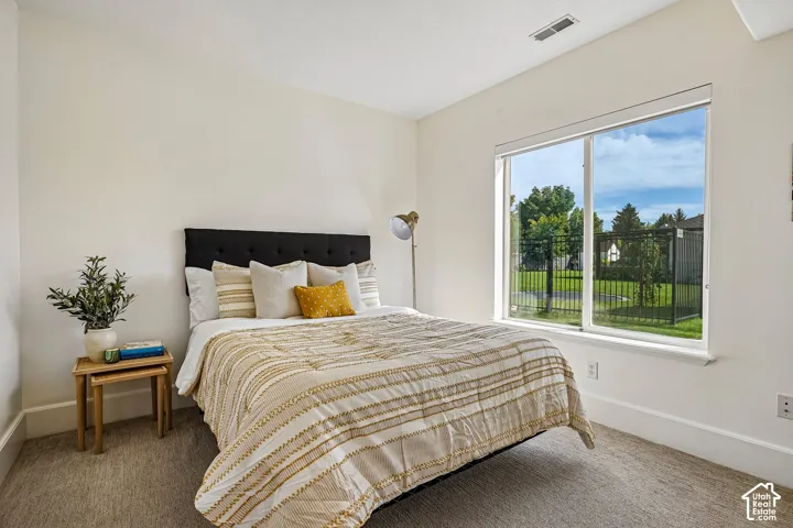 White walls with substantial baseboards, a large picture window, and carpeted flooring