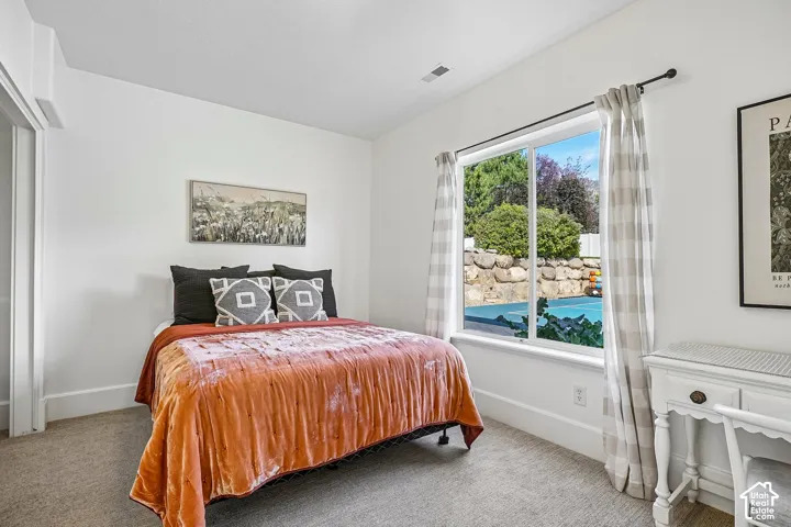 Large window, carpeted flooring, white walls, and bright overhead lighting
