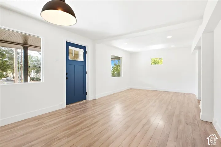Light wood-finish flooring, white walls, and recessed lighting