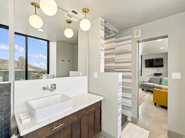 Modern vanity with a rectangular vessel sink, wall-mounted faucet, and wood-finish cabinetry