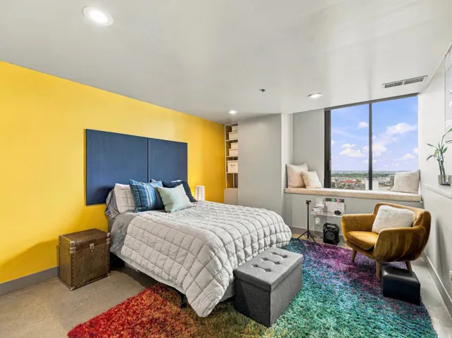 Recessed lighting, large window with built-in window seat, built-in shelving, and light-toned flooring