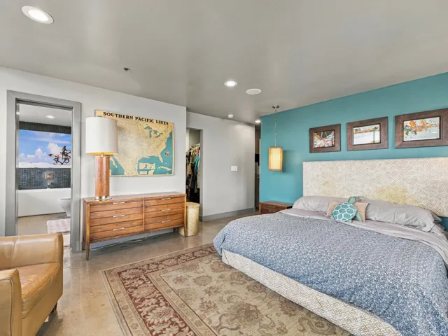 Recessed ceiling lighting, concrete flooring, and an accent wall