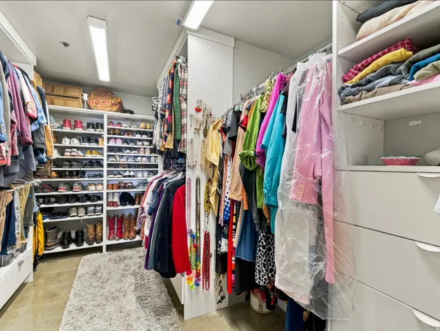 Custom built-in closet system featuring extensive shelving, multiple hanging rods, and integrated drawer storage