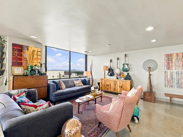 Expansive window wall, recessed lighting, concrete flooring, and built-in wood-finish cabinetry