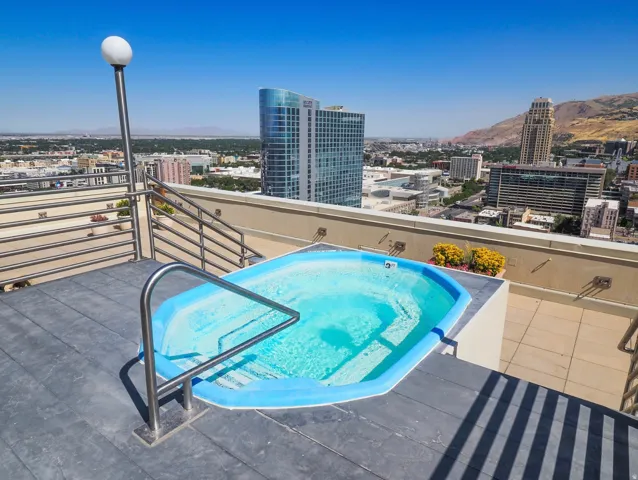 Rooftop patio featuring an in-ground spa, metal railings, and a distinct floor surface