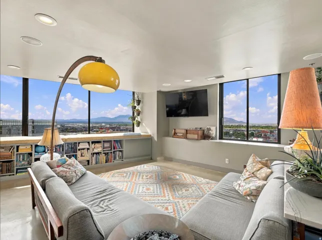 Expansive living area with large windows, recessed ceiling lights, and built-in shelving