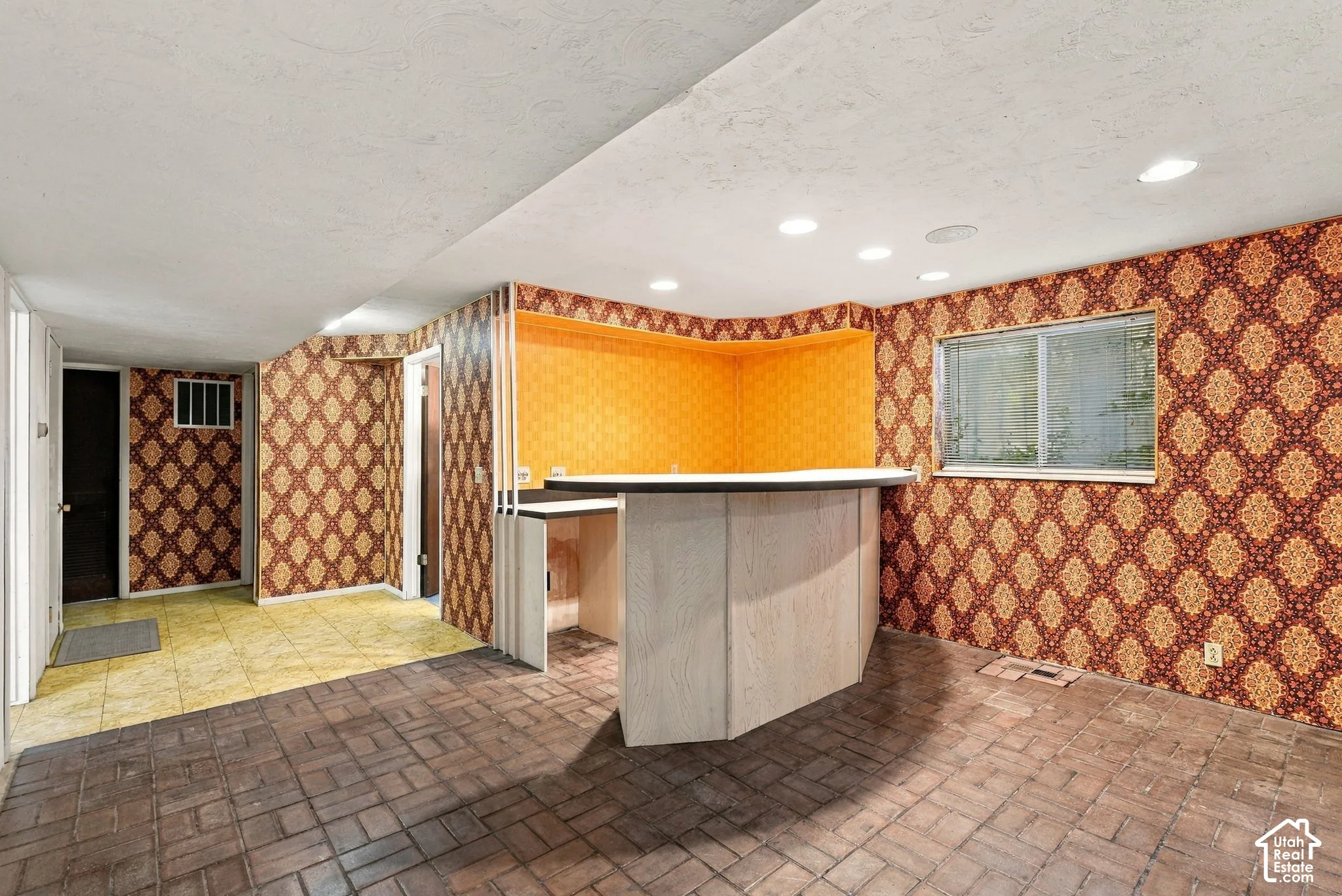 Built-in bar with a white countertop and contrasting orange back wall
