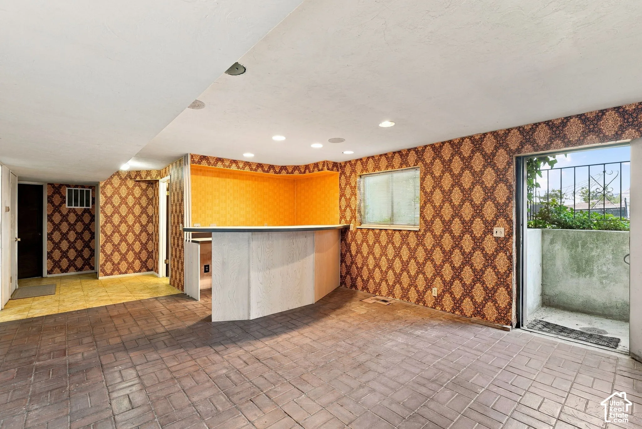 Brick-patterned flooring with a built-in bar and recessed lighting