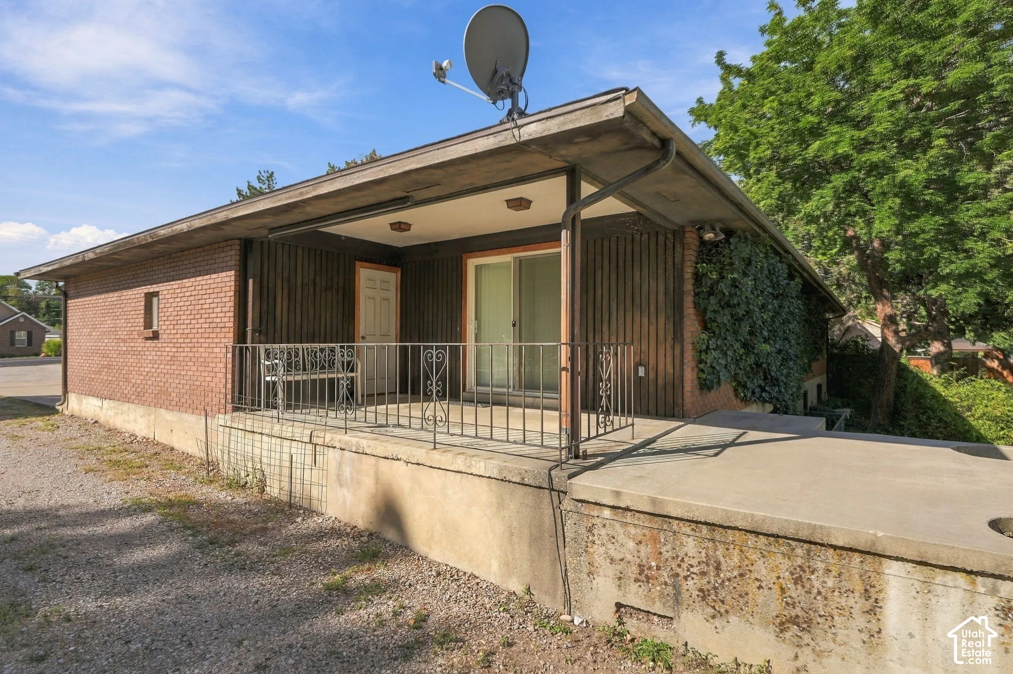 Brick exterior with vertical wood paneling and an elevated covered patio