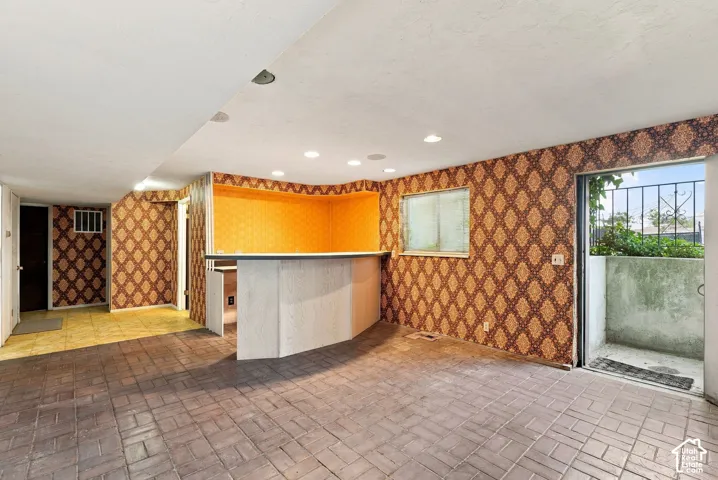 Brick-patterned flooring with a built-in bar and recessed lighting