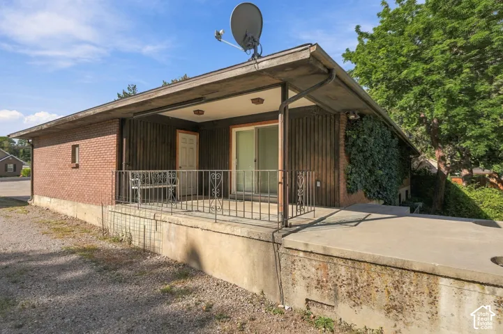 Brick exterior with vertical wood paneling and an elevated covered patio