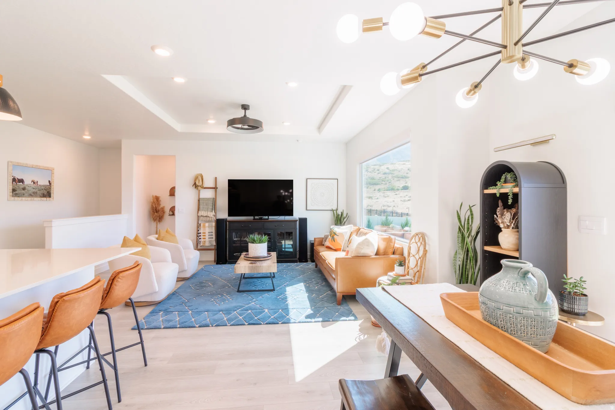 Open-concept living area featuring a tray ceiling, recessed lighting, and a modern ceiling fan