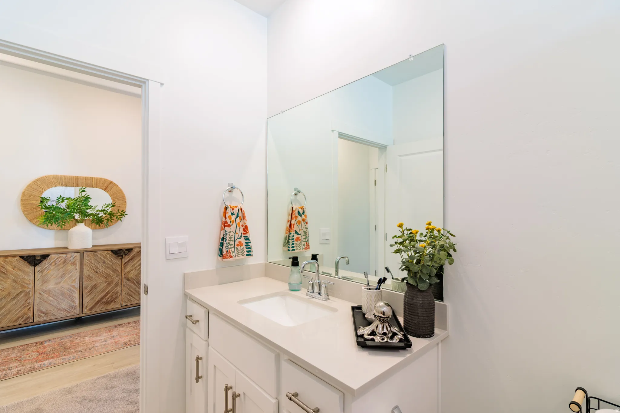 White vanity with an integrated sink, polished chrome faucet, and light-toned countertop