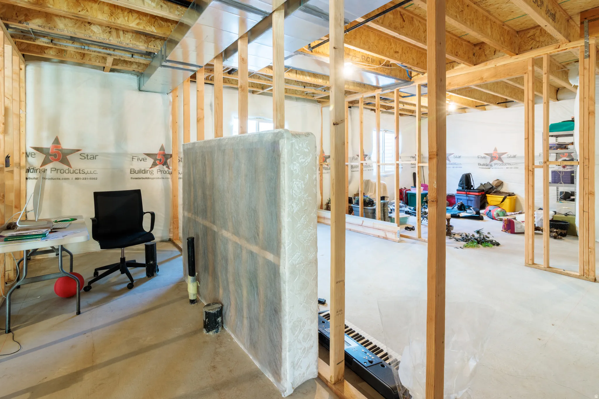 Unfinished basement featuring exposed wood framing, concrete flooring, and visible ductwork