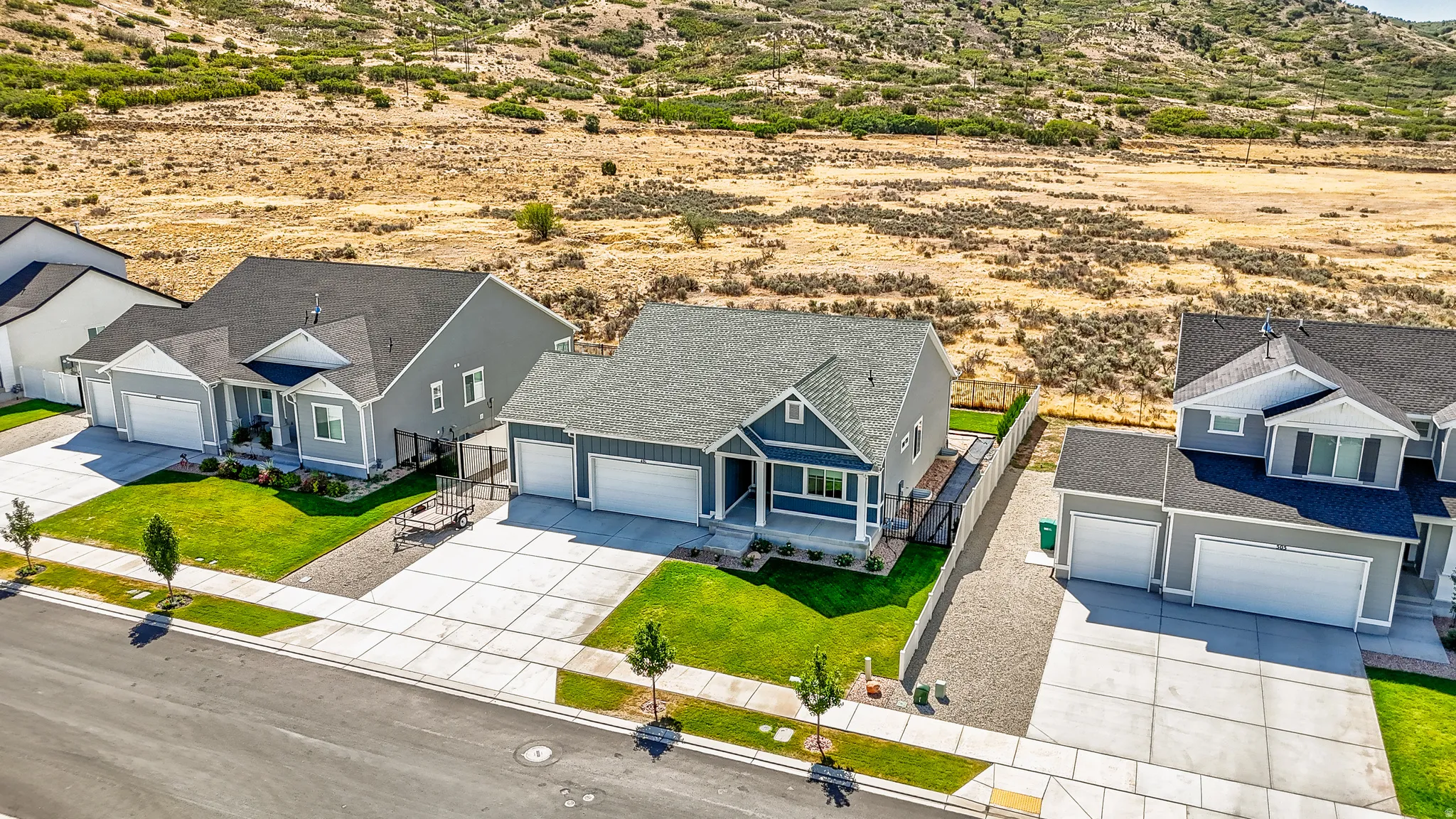 Two-story property with a two-car garage, gray siding, and a fenced backyard