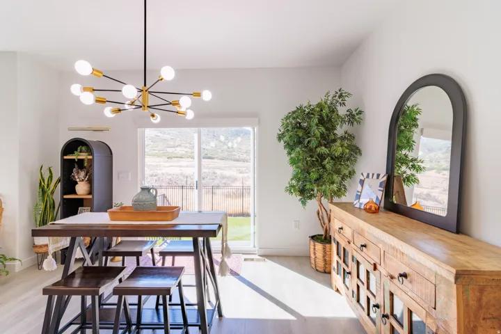 Modern sputnik chandelier illuminating a dining area with light wood-finish flooring