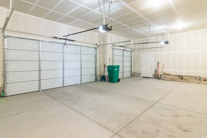 Concrete flooring, multiple garage doors, automatic garage door openers, interior access door, unfinished walls