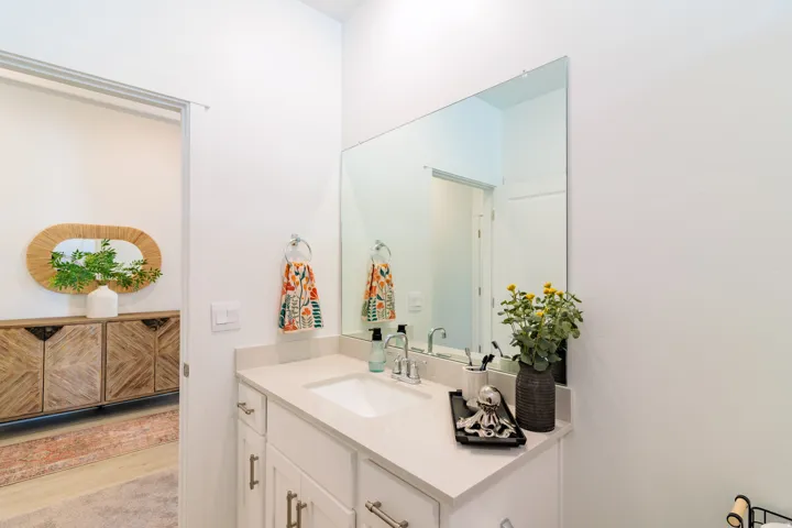 White vanity with an integrated sink, polished chrome faucet, and light-toned countertop