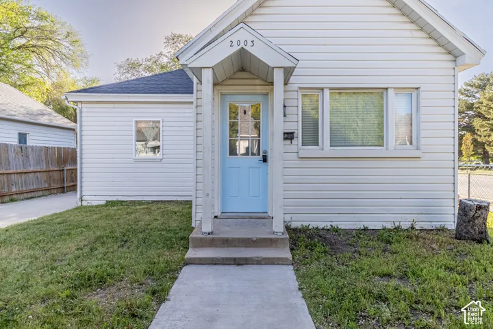 White horizontal siding exterior with a light blue entry door