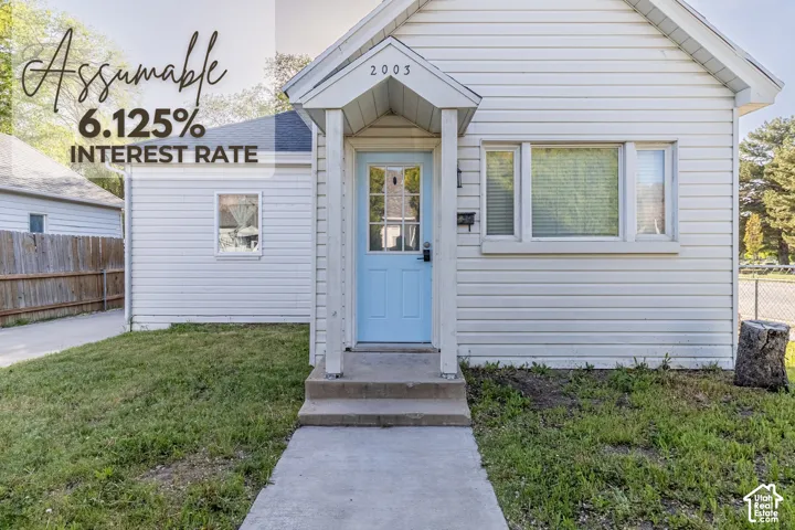 White horizontal siding exterior with a light blue front door, covered entry, and concrete walkway