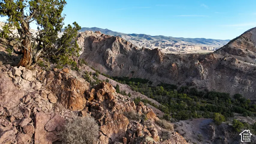Rugged mountainous terrain with natural rock formations and scattered evergreen trees