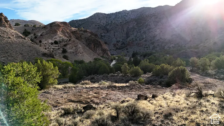 Mountainous terrain featuring diverse natural vegetation and a visible water body