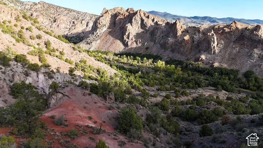 Mountainous terrain with natural rock formations, lush green foliage, and varied elevations