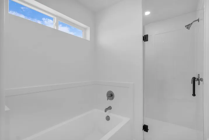 Primary bath includes soaker tub and large, walk-in shower with two shower heads.