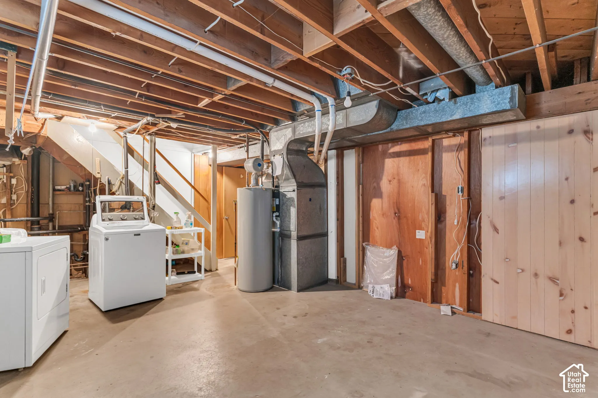 Unfinished basement with exposed ceiling joists and concrete flooring