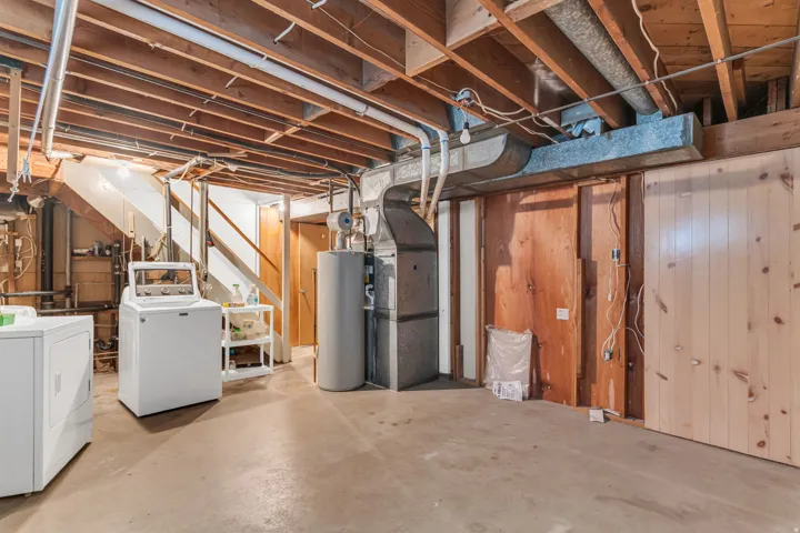 Unfinished basement with exposed ceiling joists and concrete flooring