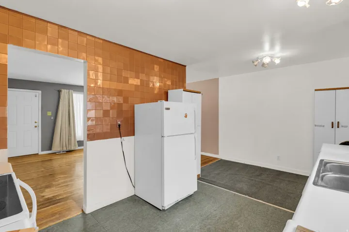 Kitchen with a built-in stainless steel sink, overhead lighting, and ample cabinet storage