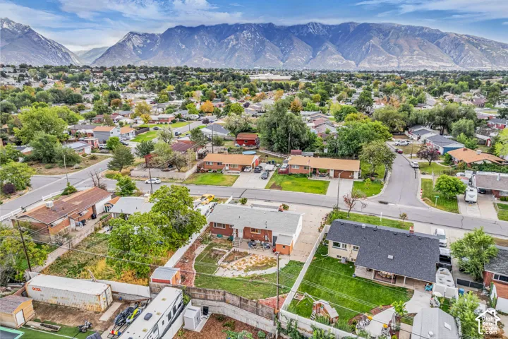 Residential neighborhood with mature trees, mountain backdrop, and paved streets