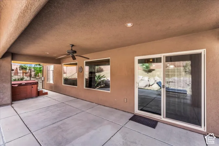 Covered patio with a built-in spa, ceiling fan, recessed lighting, and multiple windows