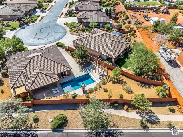Residential property featuring a tiled roof, a swimming pool, and a paved patio area