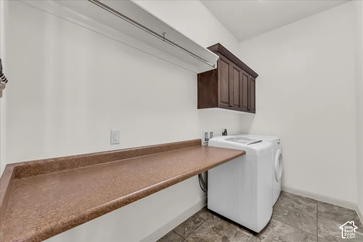 Laundry area featuring a built-in folding counter, wall-mounted cabinetry, clothing rod, and tiled flooring