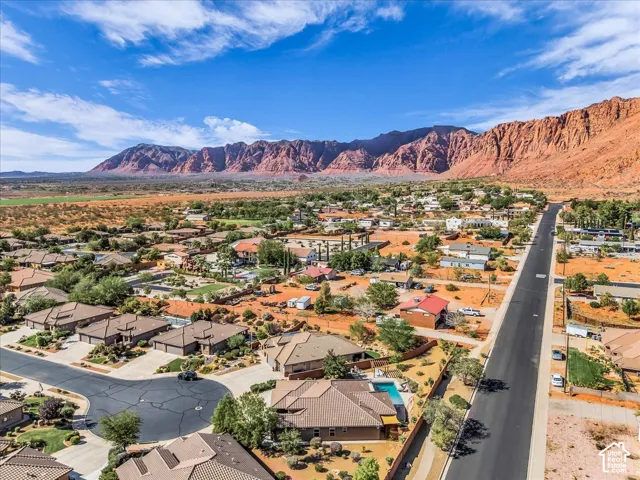 Expansive residential area with a prominent paved road, surrounded by natural desert landscaping and mature trees