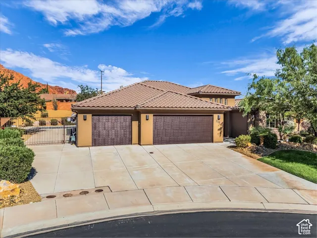 Stucco exterior with a tile roof and two garage doors