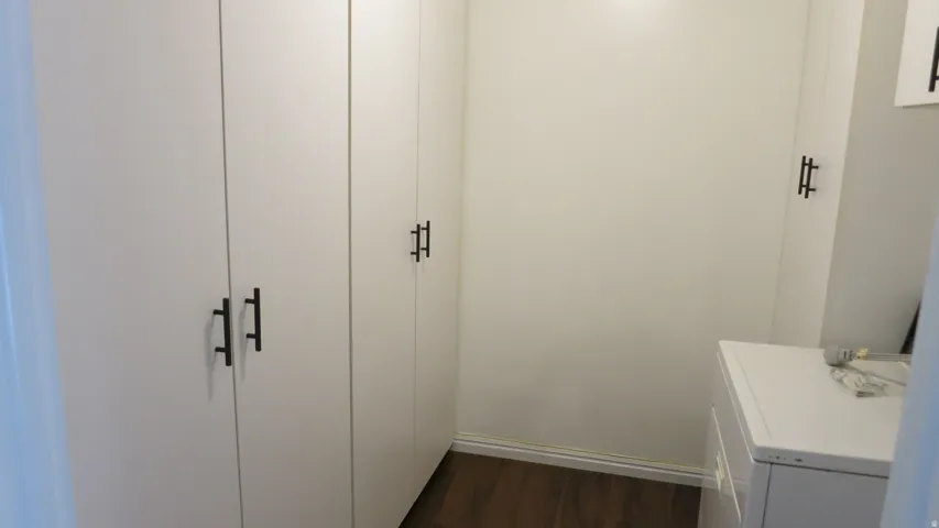 Built-in white cabinetry with matte black hardware and wood-finish flooring